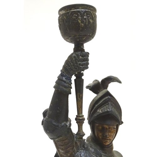 1035 - A pair of early 20thC candlesticks formed as French armoured knights, each measuring 15