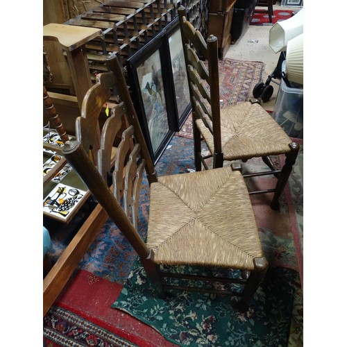 213 - A pair of 20thC rush seated ladder back dining chairs. Each approx. 37