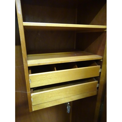 220 - A 2 door light oak wardrobe by E. Gomme. Approx. 70