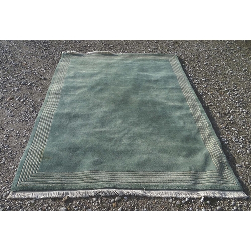 219 - A large hall rug with a grey and blue ground with a white border. Approx. 68