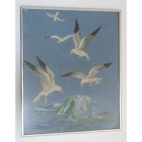 1024 - A 20thC embroidery depicting seagulls in flight over a crashing wave. Approx. 15 1/4