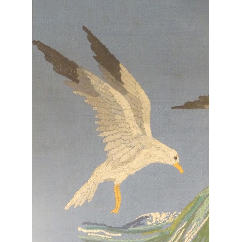 1024 - A 20thC embroidery depicting seagulls in flight over a crashing wave. Approx. 15 1/4