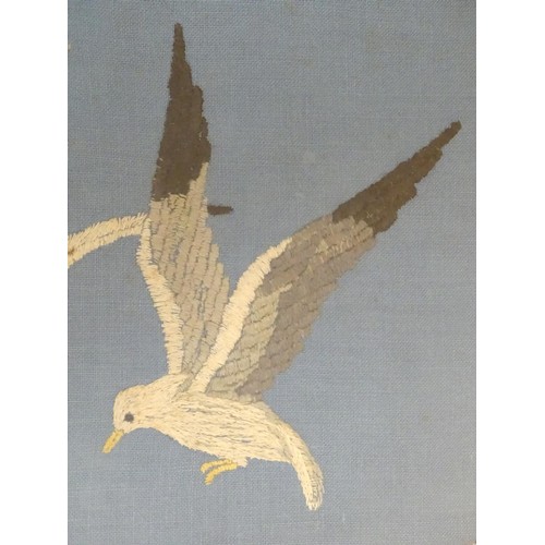 1024 - A 20thC embroidery depicting seagulls in flight over a crashing wave. Approx. 15 1/4