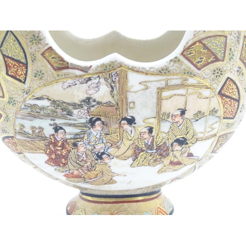 35 - A Japanese satsuma moon basket vase with hand painted decoration depicting figures seated around imp... 