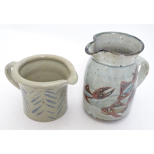 66 - Two studio pottery jugs, one with stylised fish decoration, the other with brushwork chevron detail.... 