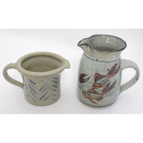 66 - Two studio pottery jugs, one with stylised fish decoration, the other with brushwork chevron detail.... 