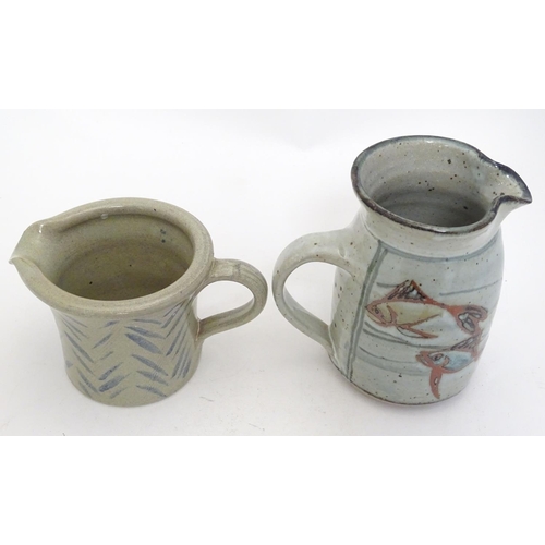 66 - Two studio pottery jugs, one with stylised fish decoration, the other with brushwork chevron detail.... 