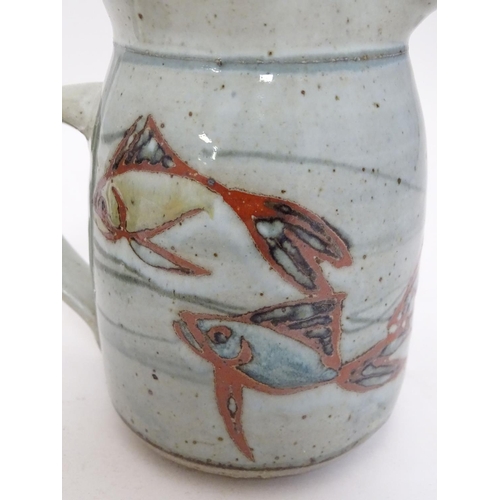 66 - Two studio pottery jugs, one with stylised fish decoration, the other with brushwork chevron detail.... 