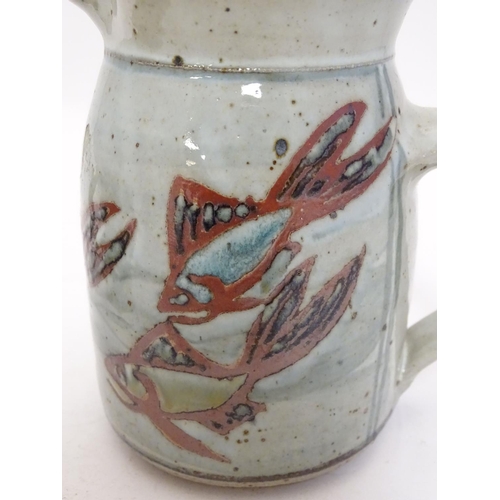 66 - Two studio pottery jugs, one with stylised fish decoration, the other with brushwork chevron detail.... 