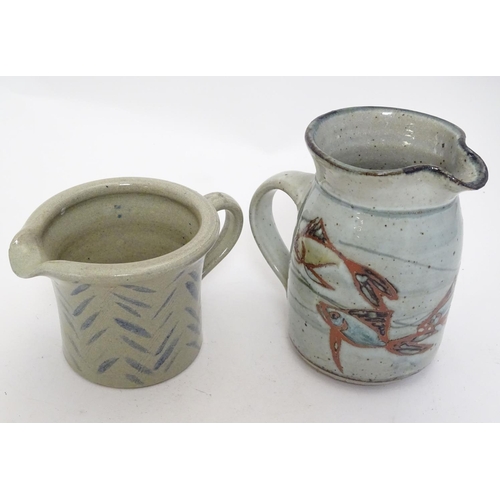 66 - Two studio pottery jugs, one with stylised fish decoration, the other with brushwork chevron detail.... 