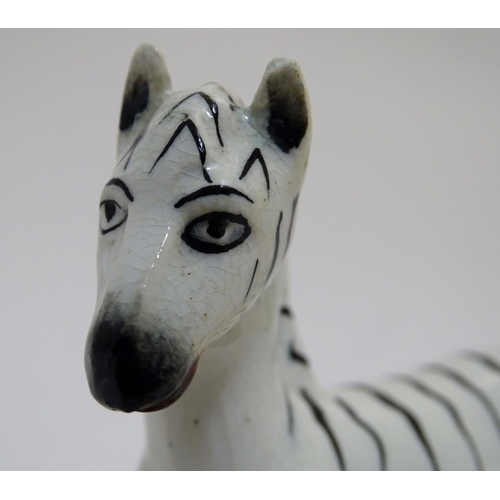 69 - A Staffordshire figure modelled as a zebra on a naturalistic oval base. Approx. 4 3/4