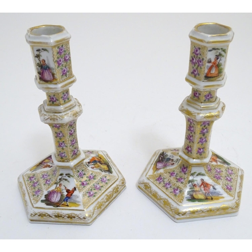 80 - A pair of Berlin porcelain candlesticks on hexagonal bases with gilt and floral detail and hand pain... 