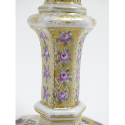 80 - A pair of Berlin porcelain candlesticks on hexagonal bases with gilt and floral detail and hand pain... 