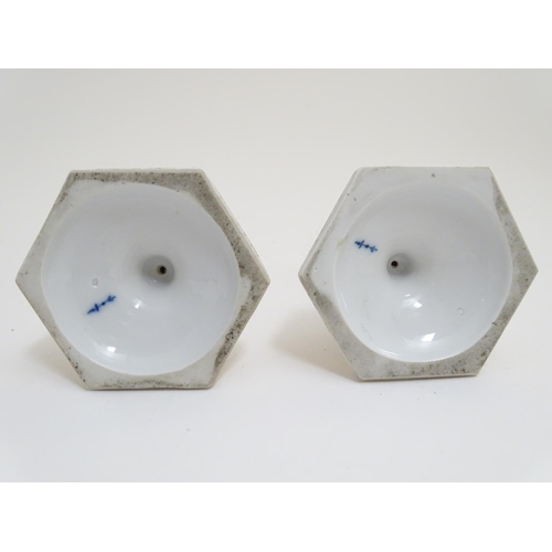 80 - A pair of Berlin porcelain candlesticks on hexagonal bases with gilt and floral detail and hand pain... 