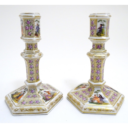 80 - A pair of Berlin porcelain candlesticks on hexagonal bases with gilt and floral detail and hand pain... 