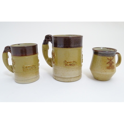 92 - Three Denby two tone stoneware tankards / mugs, two with relief hunting scenes and handles formed as... 