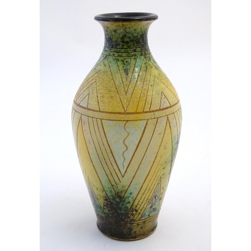 112 - A 20thC studio pottery baluster vase with incised geometric decoration. Impressed G maker's mark und... 