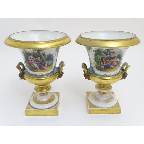 134 - A pair of hand painted twin handled campagna urns, each decorated with a young seated couple on a bl... 