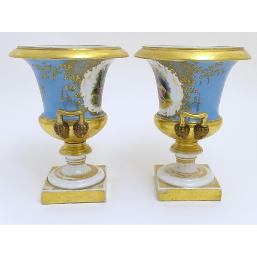 134 - A pair of hand painted twin handled campagna urns, each decorated with a young seated couple on a bl... 