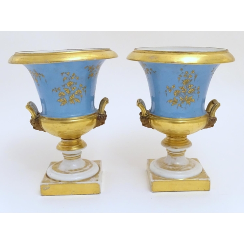 134 - A pair of hand painted twin handled campagna urns, each decorated with a young seated couple on a bl... 