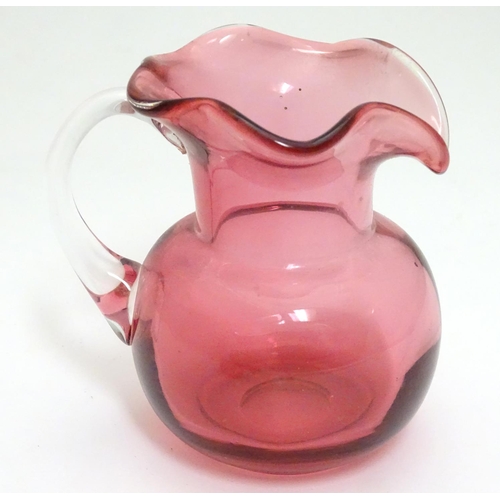 176 - An early 20thC cranberry glass jug, together with a cranberry glass salt and silver plate spoon of s... 