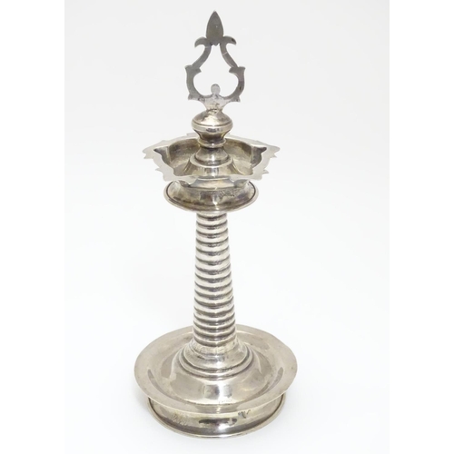 205 - A white metal Indian Puja / Diya oil lamp, with 5 point reservoir to top, on a cylindrical stem with... 