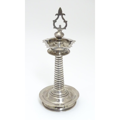 205 - A white metal Indian Puja / Diya oil lamp, with 5 point reservoir to top, on a cylindrical stem with... 