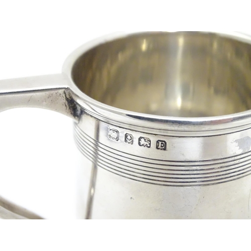 210 - A silver Christening mug  with banded detail. Hallmarked Birmingham 1929 maker A & J Zimmerman Ltd. ... 