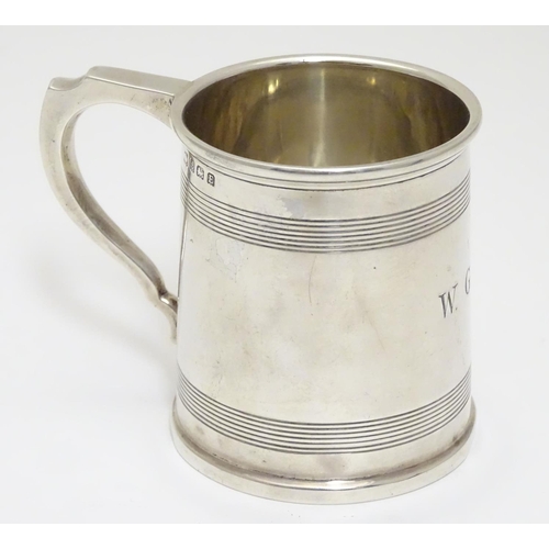 210 - A silver Christening mug  with banded detail. Hallmarked Birmingham 1929 maker A & J Zimmerman Ltd. ... 