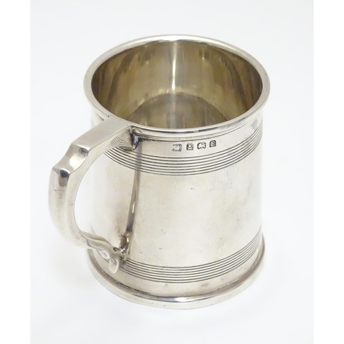 210 - A silver Christening mug  with banded detail. Hallmarked Birmingham 1929 maker A & J Zimmerman Ltd. ... 