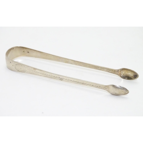 297 - Geo III silver sugar tongs with bright cut decoration hallmarked London 1791 maker GW. 5 1/4