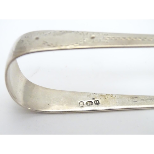 297 - Geo III silver sugar tongs with bright cut decoration hallmarked London 1791 maker GW. 5 1/4