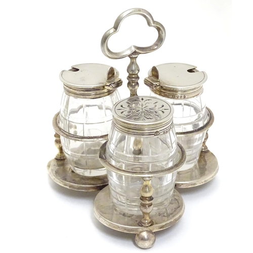 332 - A Victorian silver cruet stand with three glass bottles of barrel form with silver mounts. Hallmarke... 