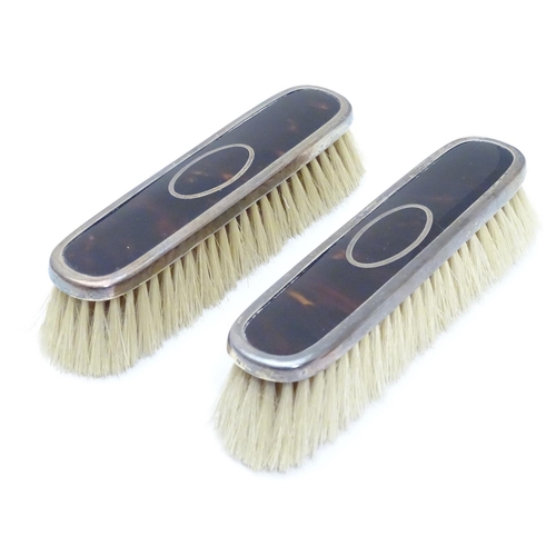 334 - A pair of silver and tortoiseshell mounted clothes brushes. Hallmarked Birmingham 1922 maker Levi & ... 