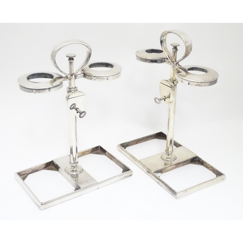 420 - A matched pair of silver plate decanter stands / tantalus with locking mechanism to central column. ... 