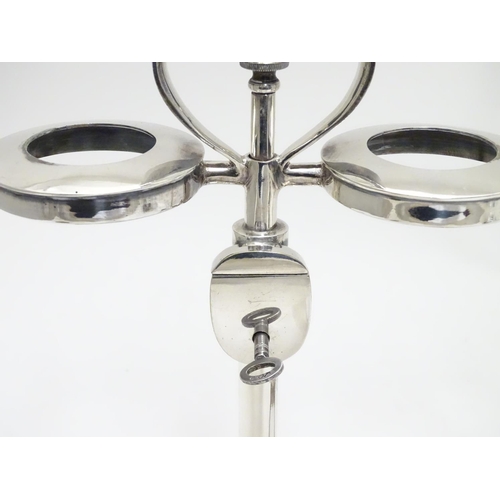 420 - A matched pair of silver plate decanter stands / tantalus with locking mechanism to central column. ... 