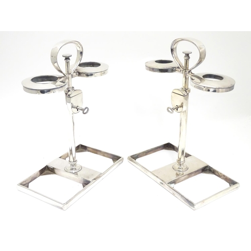 420 - A matched pair of silver plate decanter stands / tantalus with locking mechanism to central column. ... 