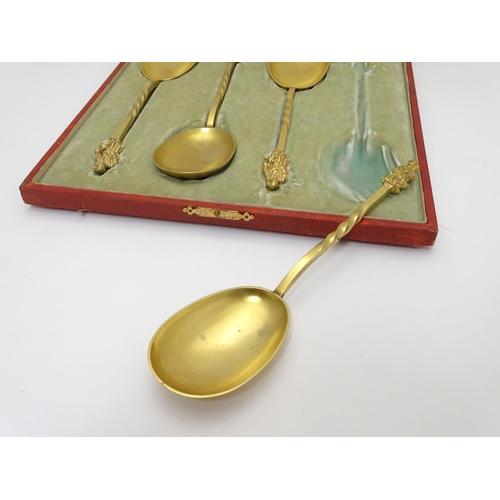 429 - A cased set of four gilded serving spoons surmounted by a religious figure. Each approx. 8