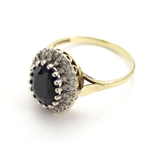 455 - A 9ct gold ring set with facet cut blue spinel bordered by diamonds. Ring size approx N.