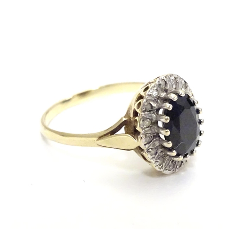 455 - A 9ct gold ring set with facet cut blue spinel bordered by diamonds. Ring size approx N.