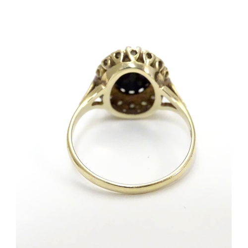 455 - A 9ct gold ring set with facet cut blue spinel bordered by diamonds. Ring size approx N.