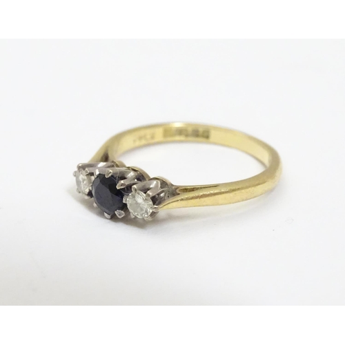 456 - An 18ct  ring set with dark blue spinel flanked by diamonds. Ring size approx I