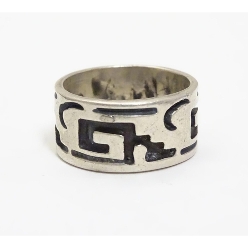 462 - A Mexican silver ring of band form with abstract detail. Ring size approx. O