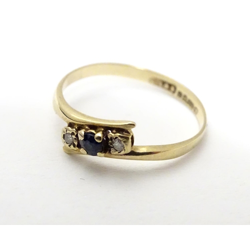 463 - A 9ct gold ring set with central spinel flanked by two white stones. Ring size approx J 1/2