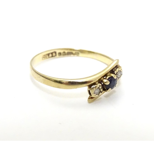 463 - A 9ct gold ring set with central spinel flanked by two white stones. Ring size approx J 1/2