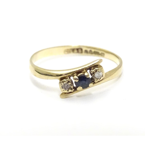 463 - A 9ct gold ring set with central spinel flanked by two white stones. Ring size approx J 1/2