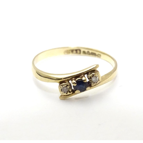 463 - A 9ct gold ring set with central spinel flanked by two white stones. Ring size approx J 1/2