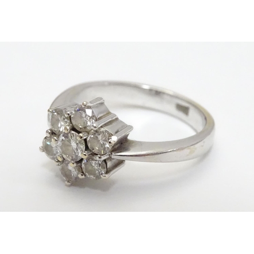 464 - An 18ct gold ring set with 7 diamonds in a daisy cluster setting. the setting approx 3/8