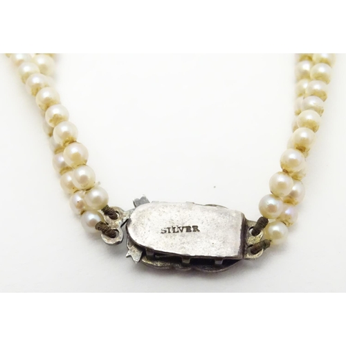 472 - A double strand pearl necklace  / choker of graduated pearls with silver and marcasite clasp. approx... 