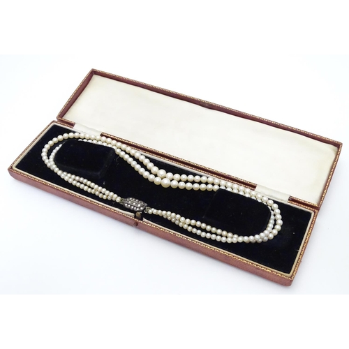 472 - A double strand pearl necklace  / choker of graduated pearls with silver and marcasite clasp. approx... 